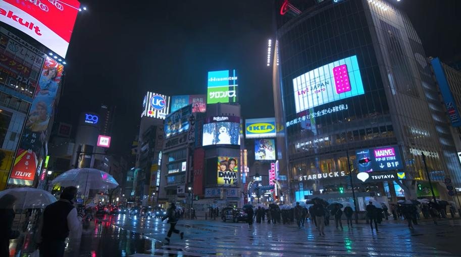 Neon-lit city street at night in the rain