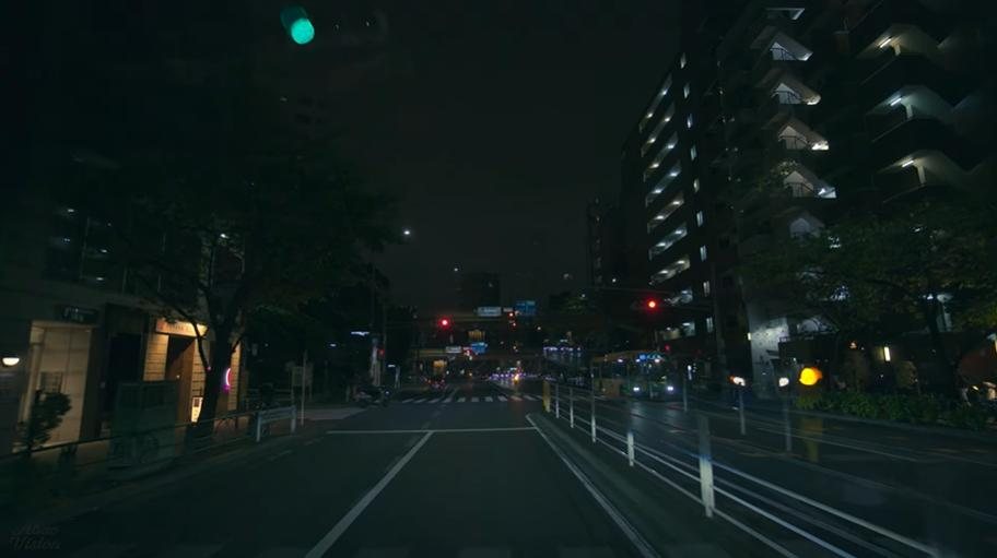Dark residential road filmed from a car at night