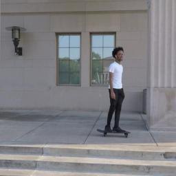 Ground-truth target: the skateboarder wears a white shirt and black trousers